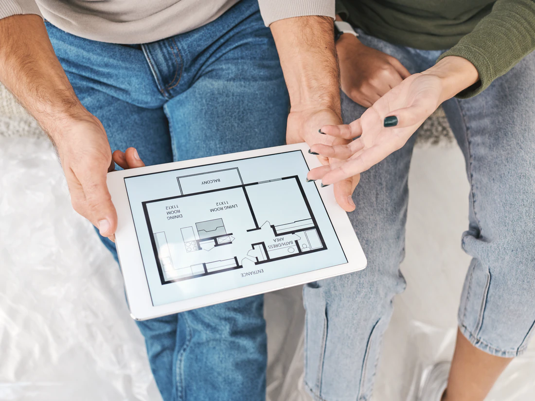 Paar sieht sich einen Grundriss auf dem Tablet an