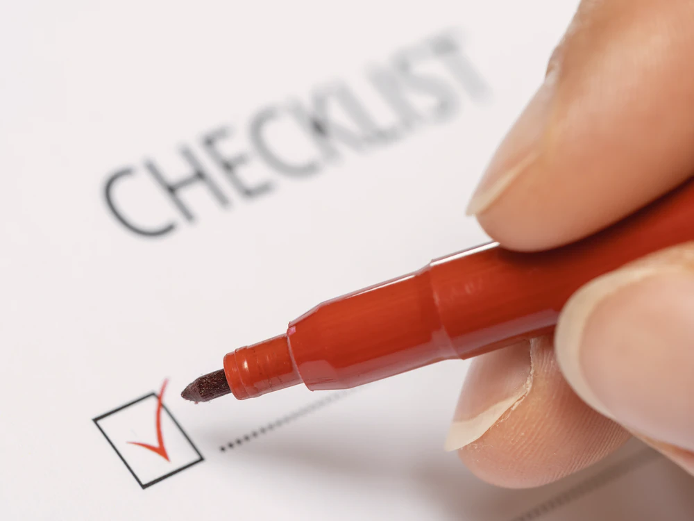 Hand hakt einen Punkt auf der Checkliste ab